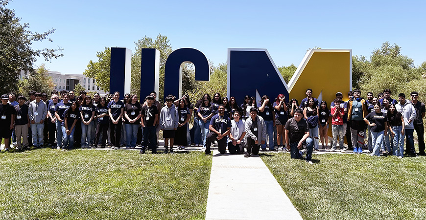 students pose in fromt of the campus's UCM letters on campus